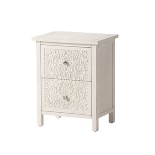 A white distressed nightstand with a floral design