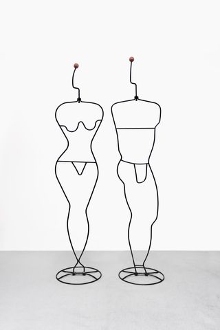 Two coat racks featuring black wired silhouettes of a woman and man