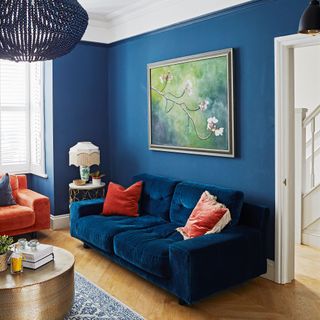 navy blue living room with navy sofa and artwork