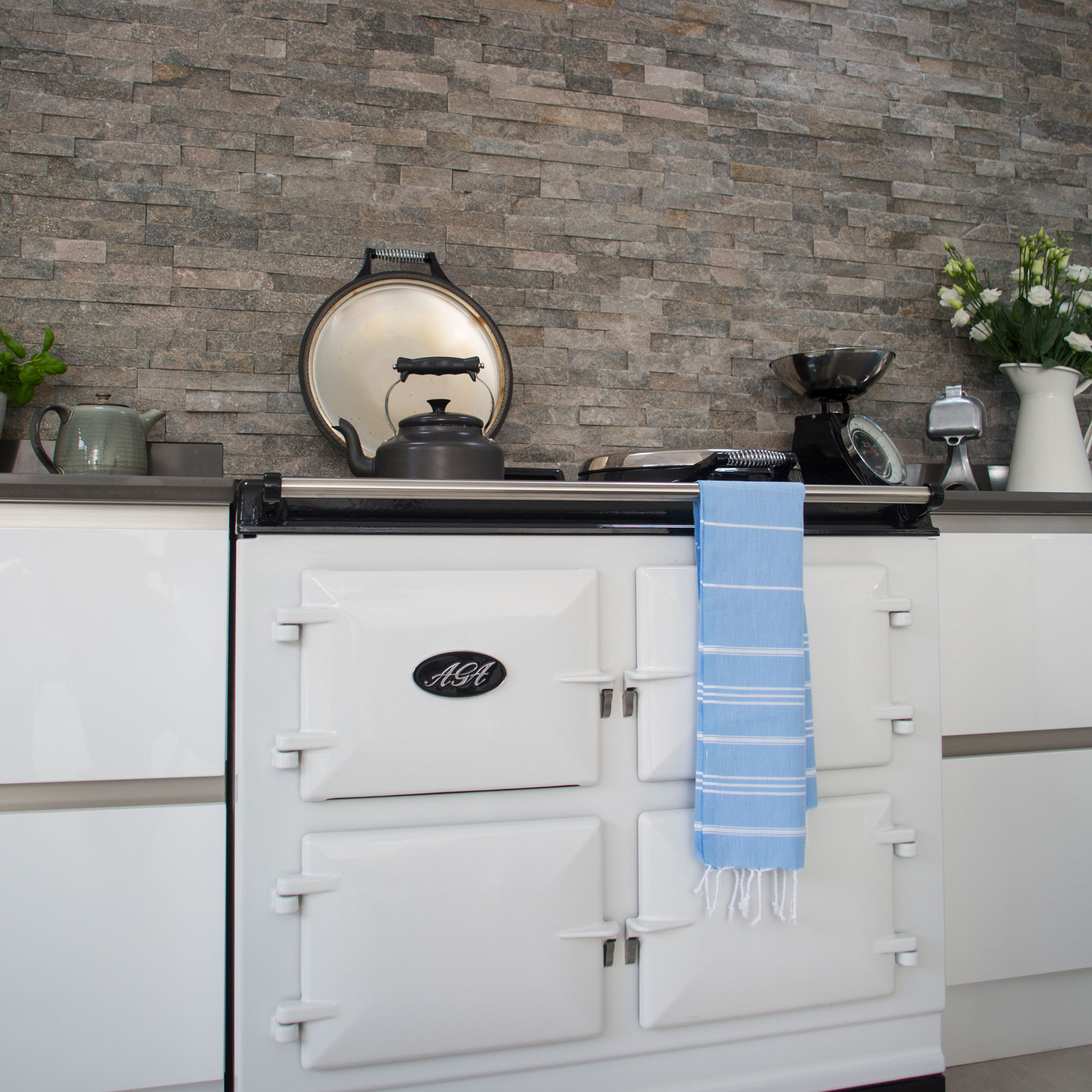 Grey wall with white cabinets and white aga