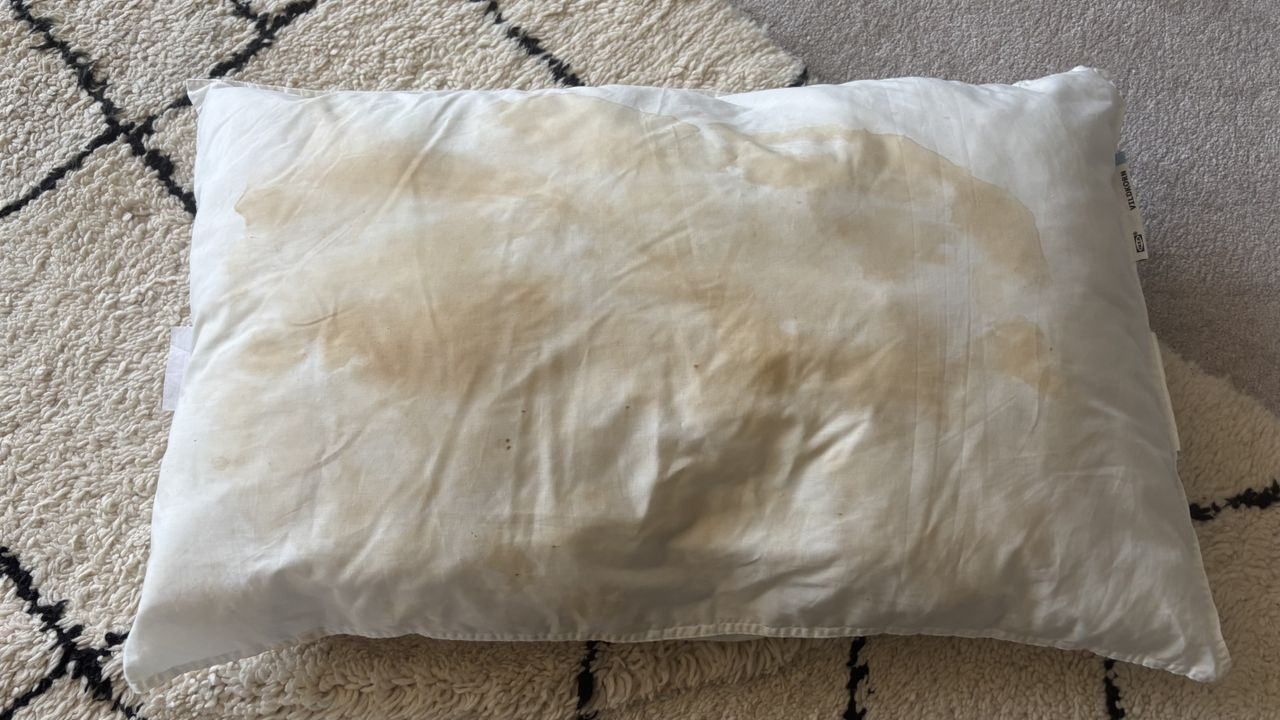 A stained pillow before being washed with detergent and soda crystals.