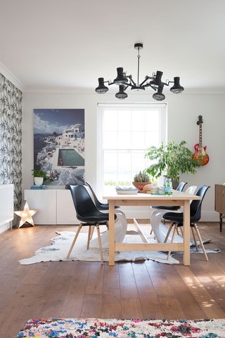 Dining room with large artwork and bold wallpaper