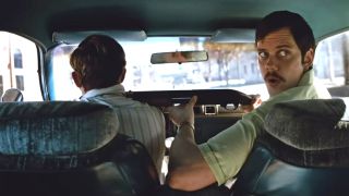 Bill Skarsgard looking forward while Dacre Montgomery drives in Dead Man's Wire