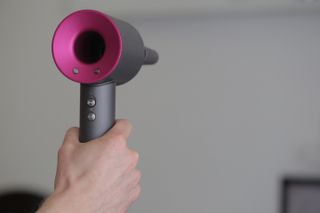 The Dyson Supersonic hair dryer being held upright