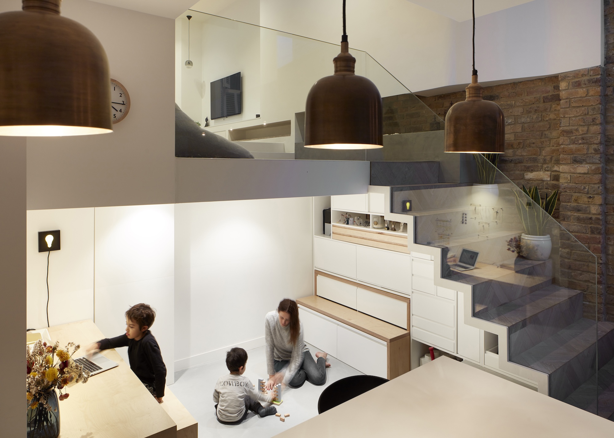 a single flexible living space showing a split level living room with a homework space under the stairs