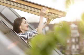 woman cleaning wooden rooflight
