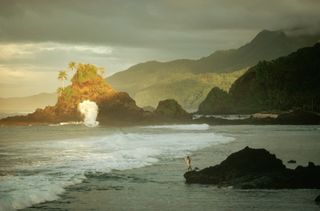 Dark sky over jagged Samoa coastline.