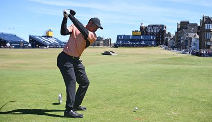 Woods hits a tee shot at the 18th hole at St Andrews
