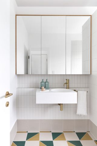A small white bathroom with colorful tiles
