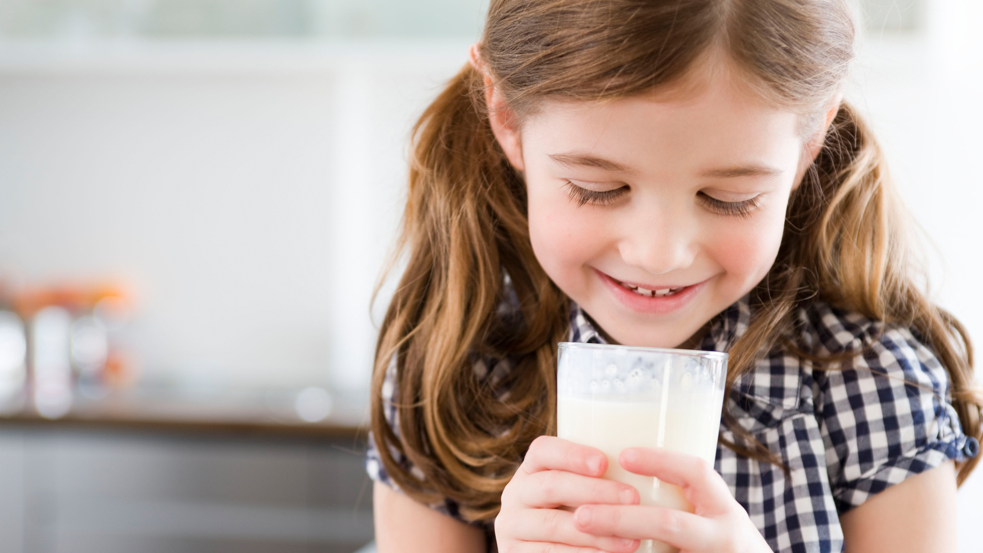 young girl holding a glass of milk