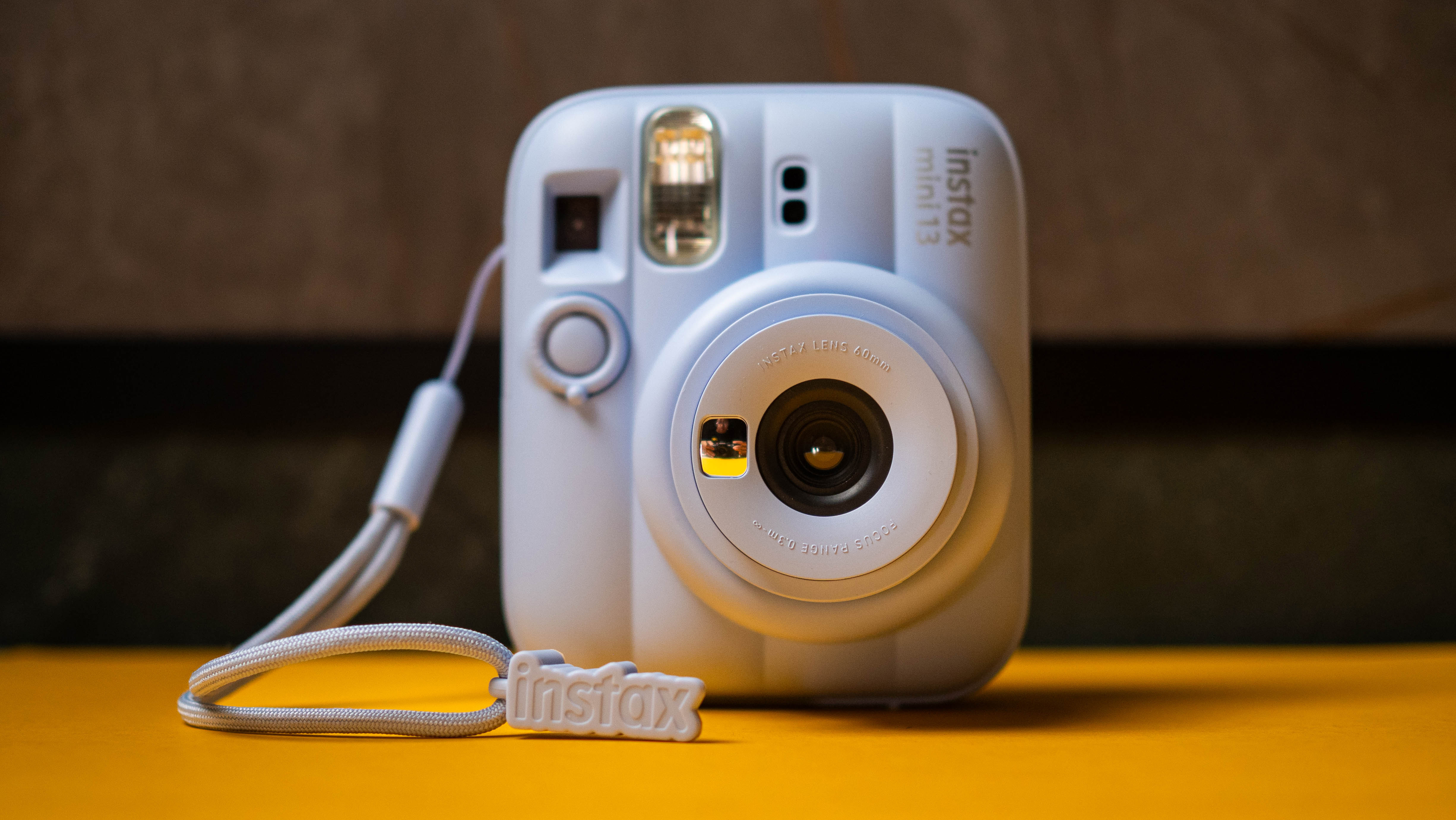 Fujifilm Instax Mini 13 instant camera against a yellow colored sheet