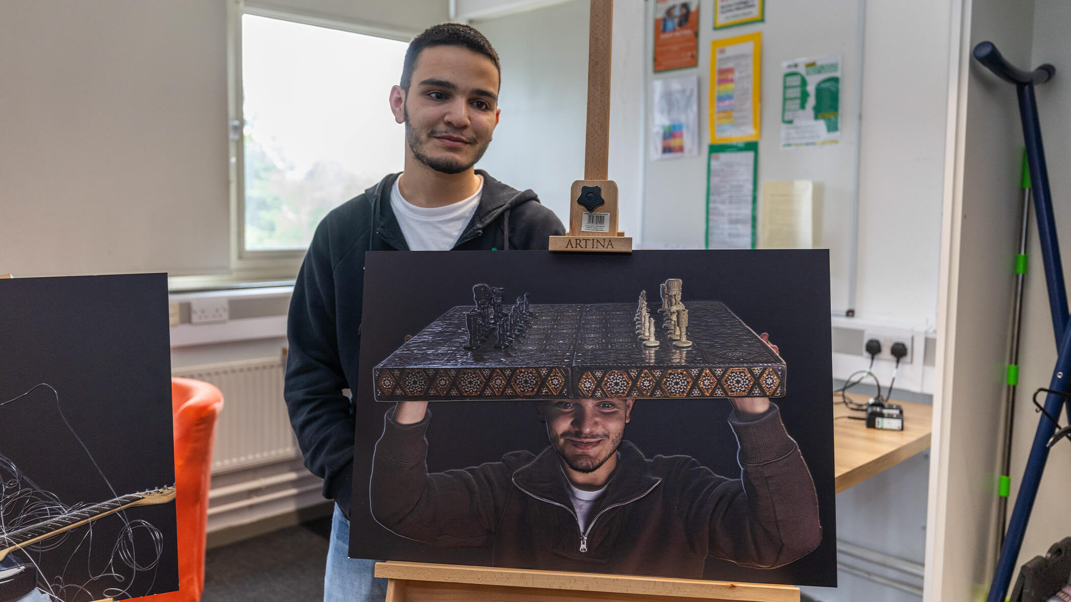 Student shows off painting they created.