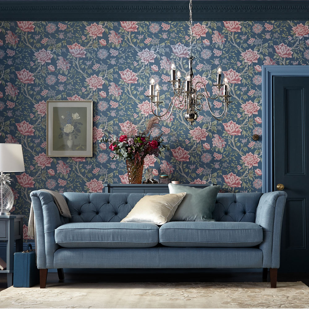 Blue living room with floral wallpaper and a candle ceiling light