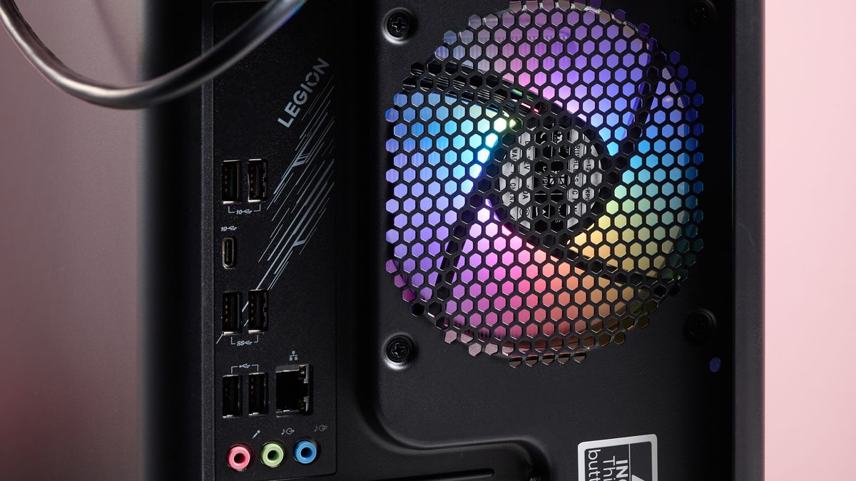Close-up of rear fan with RGB lighting on inside the Lenovo Legion Tower 5, with pink wall in background