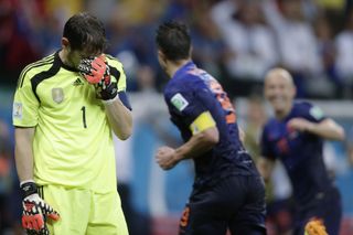 Spain goalkeeper Iker Casillas looks dejected as Robin van Persie celebrates his goal for the Netherlands in the 2014 World Cup.