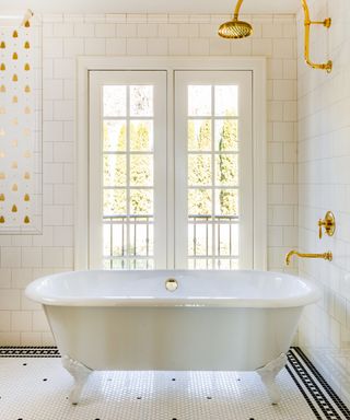 White bathroom with metro tiles, freestanding tub, brass fixtures & fittings,