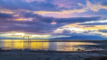 A colorful sunset sky reflection on the Salton Sea at Bombay Beach. 