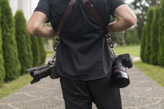 Person wearing camera harness with two cameras attached with their back turned to camera