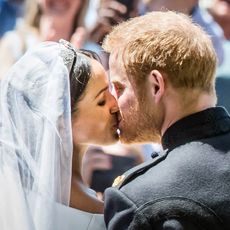 Britain's Prince Harry, Duke of Sussex kisses his wife Meghan, Duchess of Sussex as they leave from the West Door of St George's Chapel, Windsor Castle, in Windsor, on May 19, 2018 after their wedding ceremony.