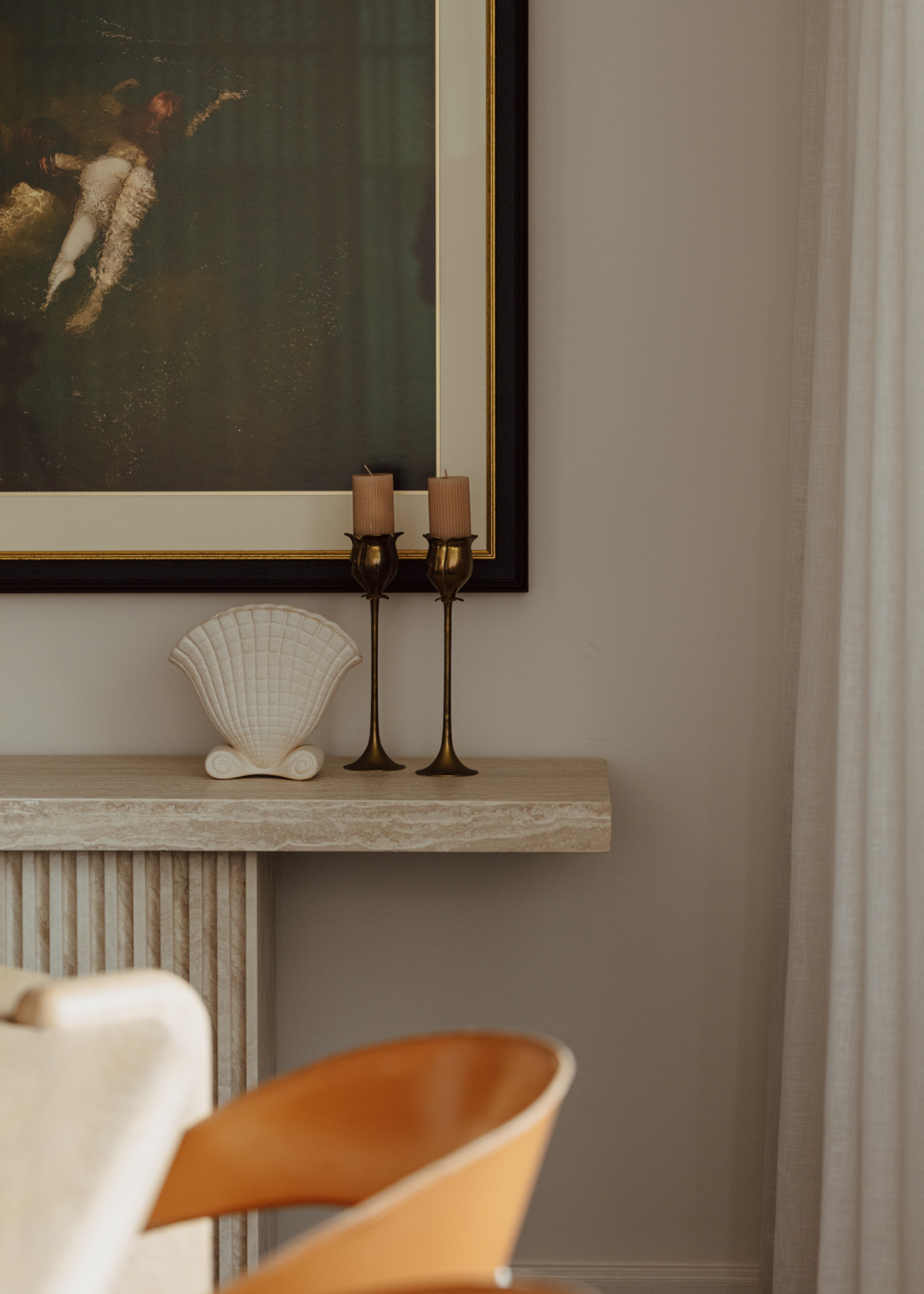 A pair of candlesticks and a shell vase on a marble pedestal