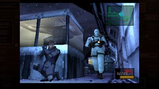 Solid Snake presses against a corner as a guard in snow gear approaches, patrolling the gated entrance to the Shadow Moses Island compound in the Master Collection release of Metal Gear Solid