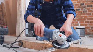 cleaning a metal pipe with an angle grinder