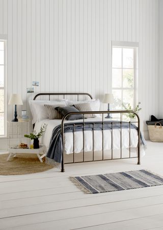 traditional wrought iron bedframe in white bedroom