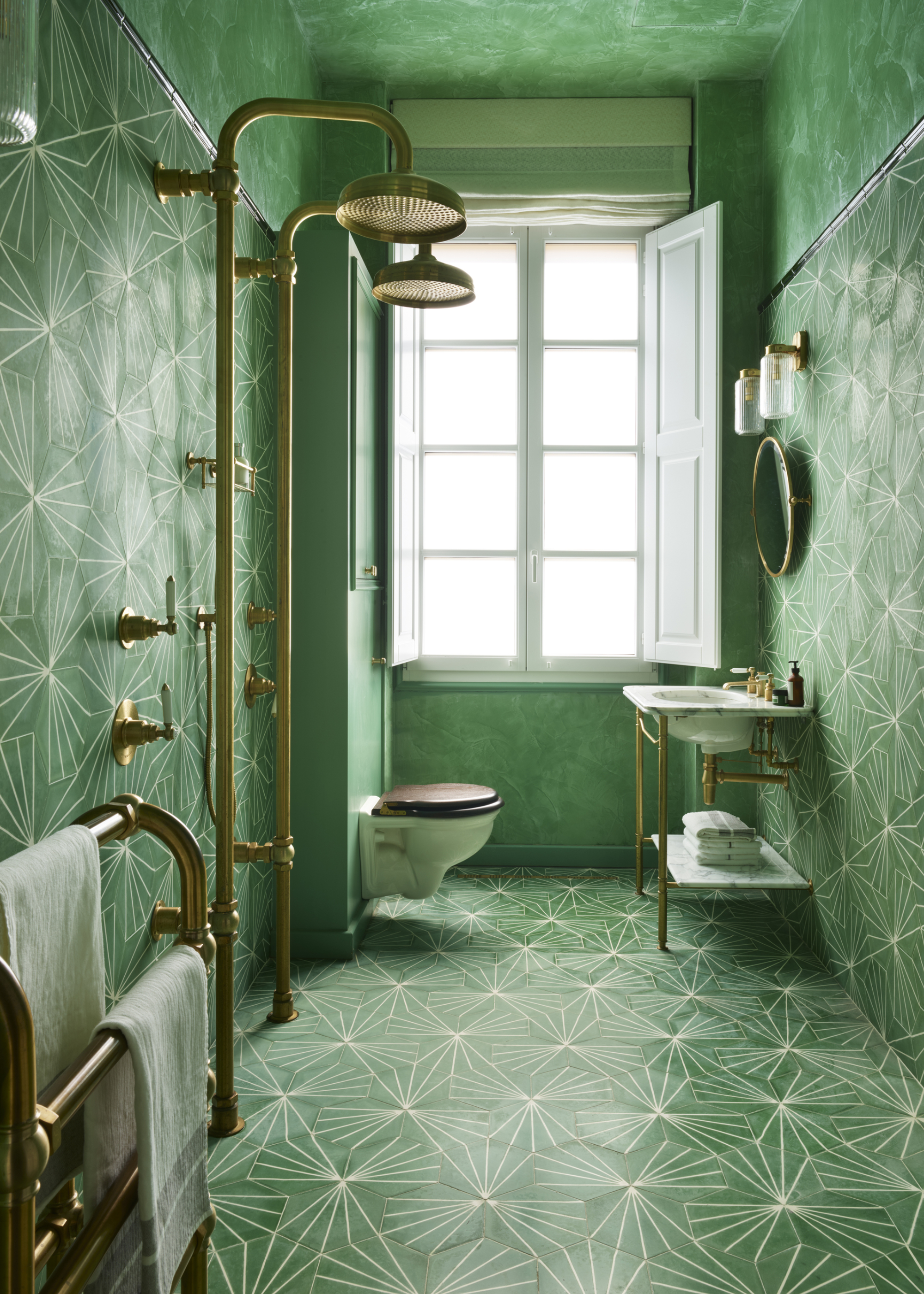 A green bathroom with a toilet, shower and sink are as well as a towel rail