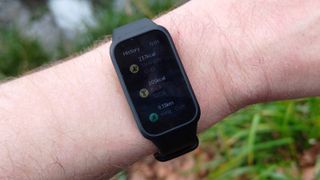 The Xiaomi Smart Band 9 Active being worn in a park.