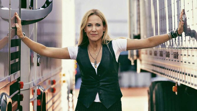 Sheryl Crow standing between two trucks