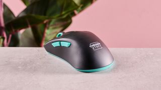 Rear of Cherry XTRFY M64 Wireless on table with pink background and plant