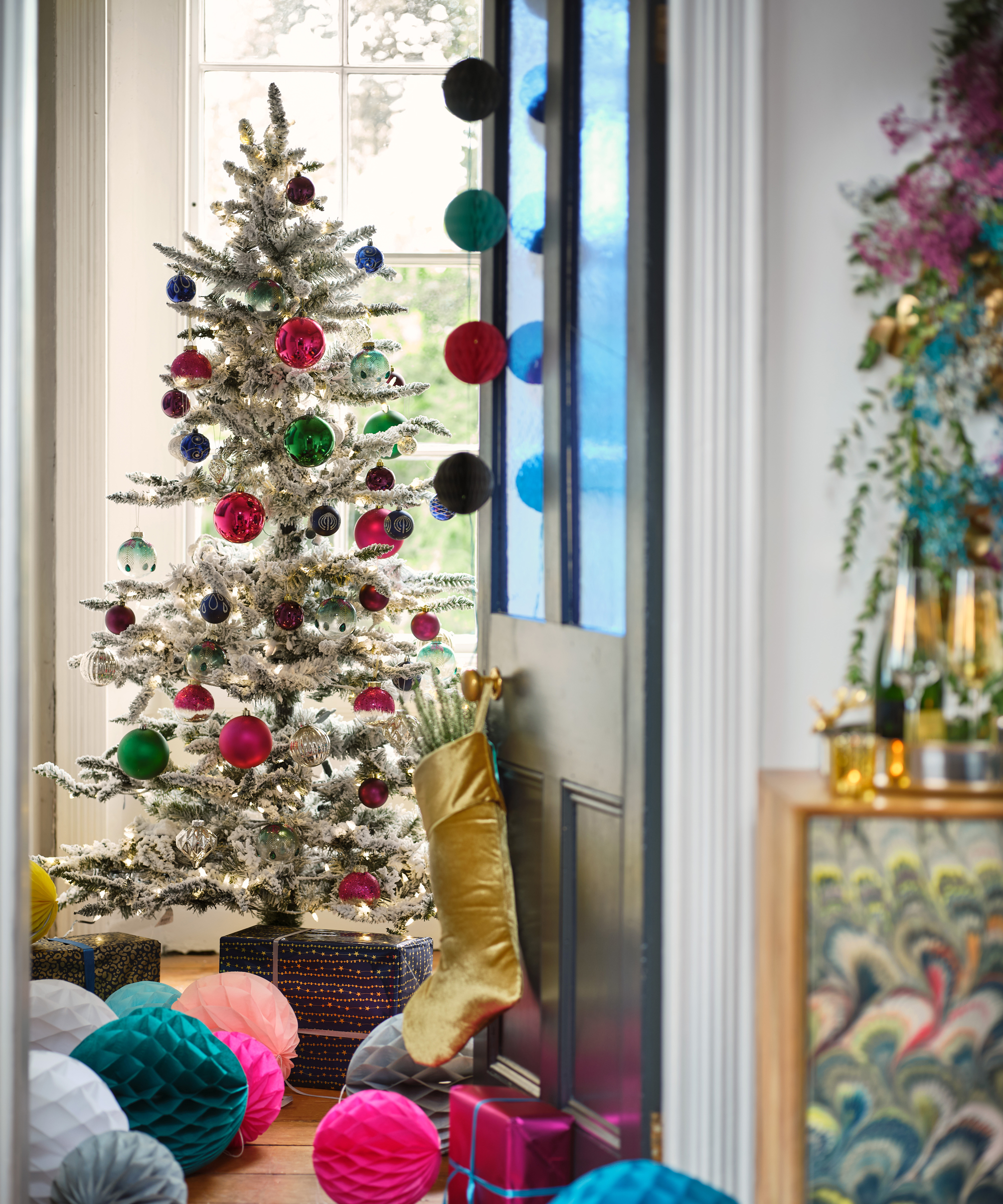 A Christmas tree and paper decorations in a hallway area