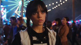 Wednesday Adams (Jenna Ortega) in a hoodie and striped polo top