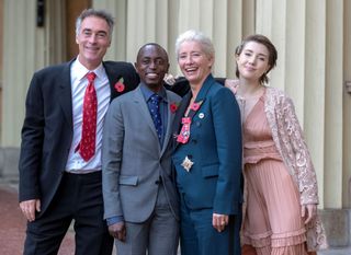 Emma Thompson poses with her husband Greg Wise (L), and children Gaia Wise (R) and Tindy Agaba, whilst wearing her medal and insignia after she was appointed a Dame Commander of the Order of the British Empire