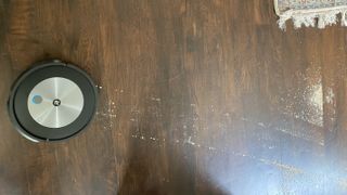 irobot j7+ vacuuming crumbs on hard wood flooring