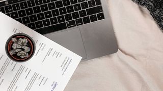 A resume next to a laptop
