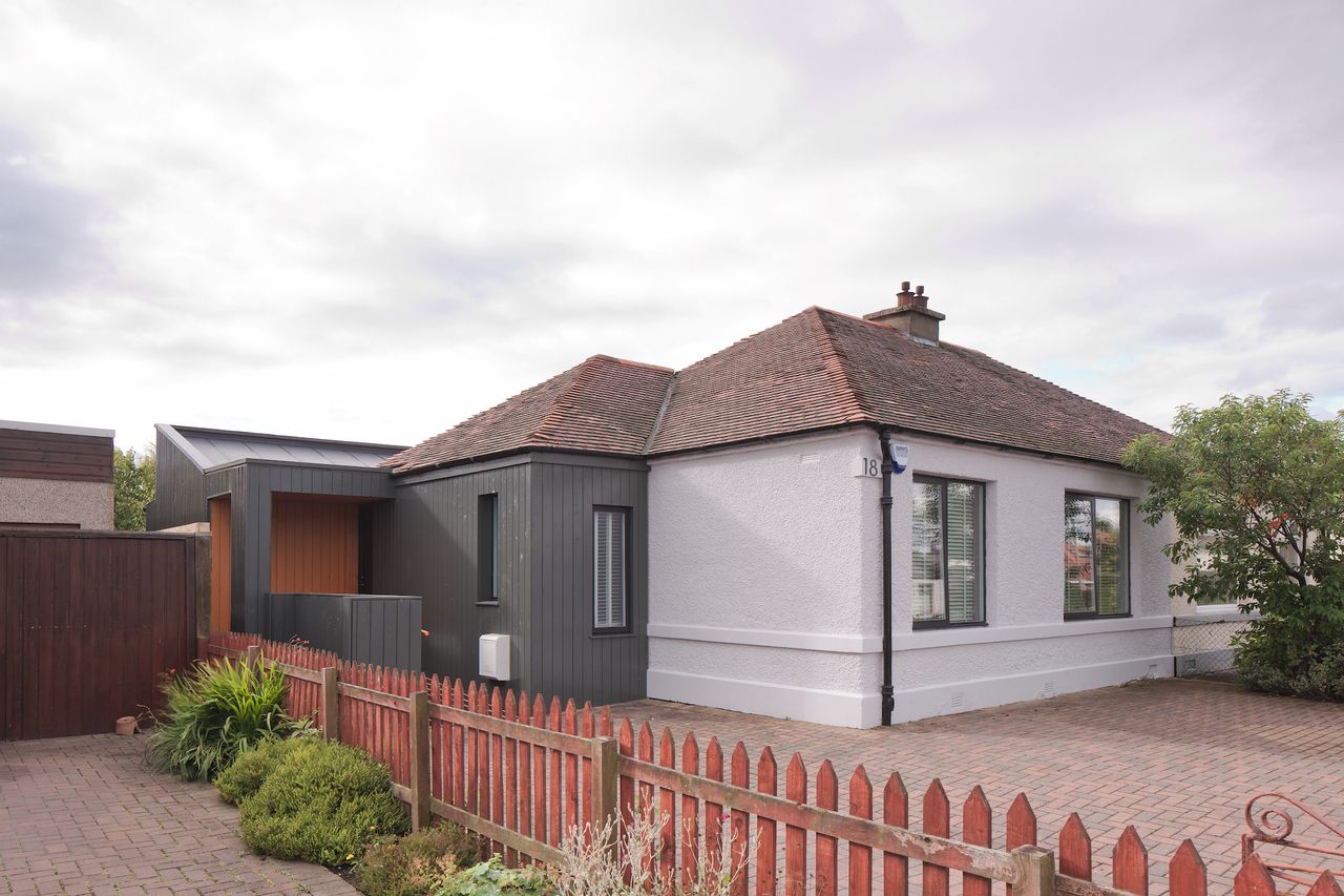grey and white painted bungalow with rear extension