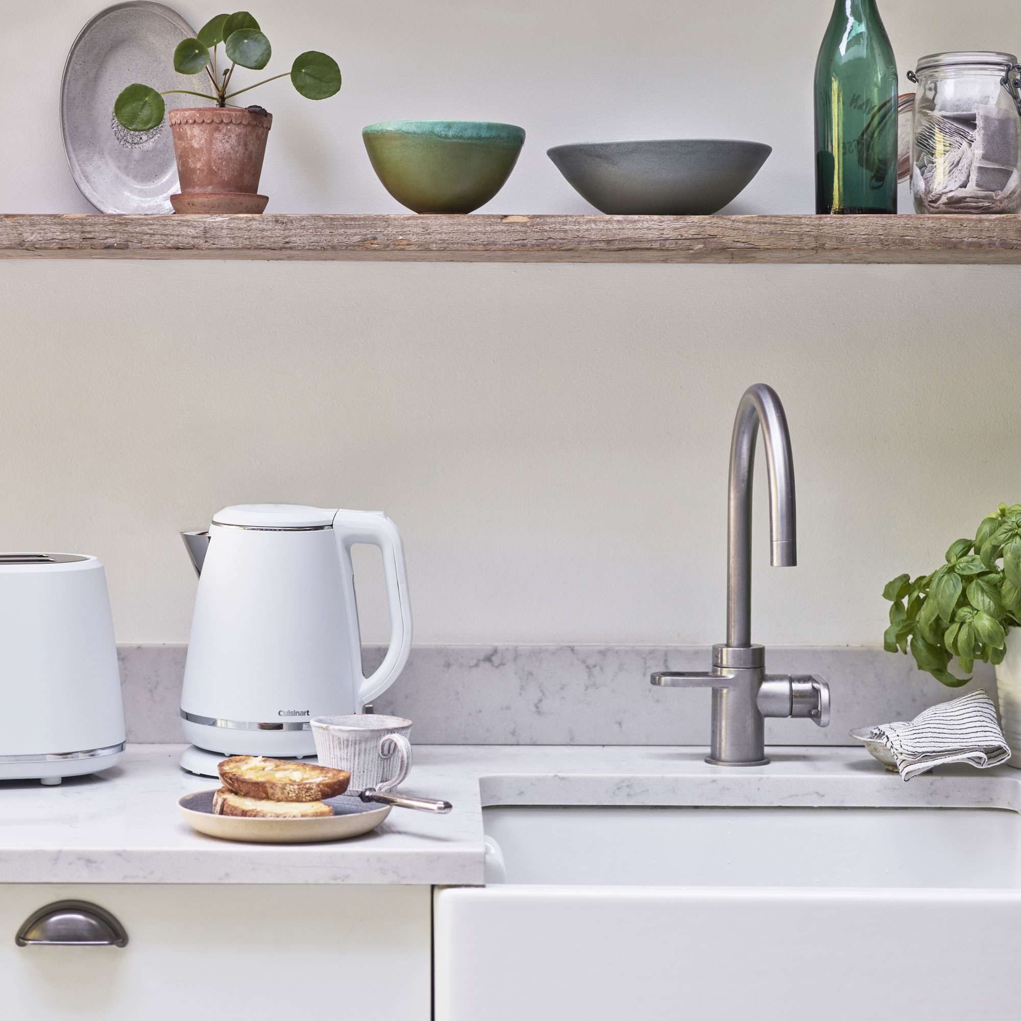 kitchen room with shelves on wall and white coloured kettle