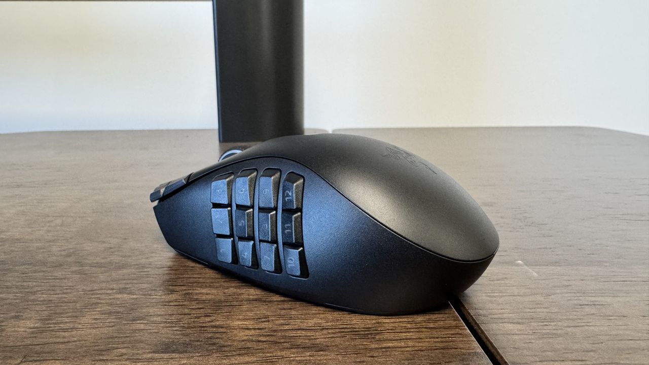 The Razer Naga V3 Pro on a wooden table from the back left