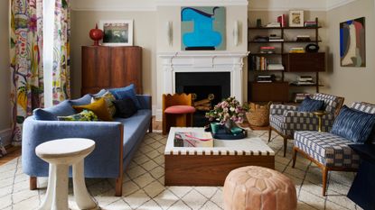 living room with blue sofa, white Berber rug and patterned blue twin chairs arranged around a fireplace