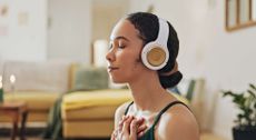 Woman, meditation and yoga in headphones listening to calm music, holistic exercise and peace in living room.