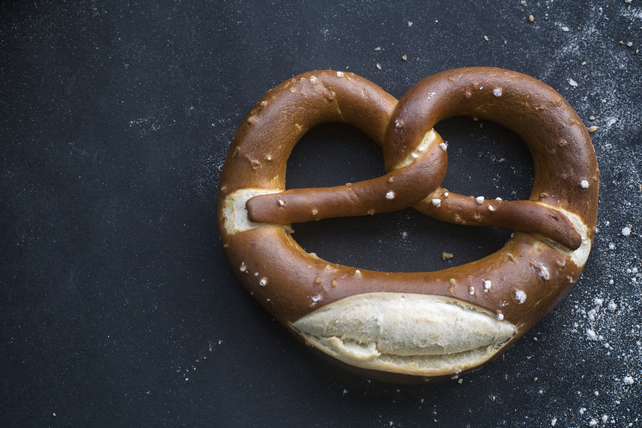 Photo of a large soft pretzel with salt.