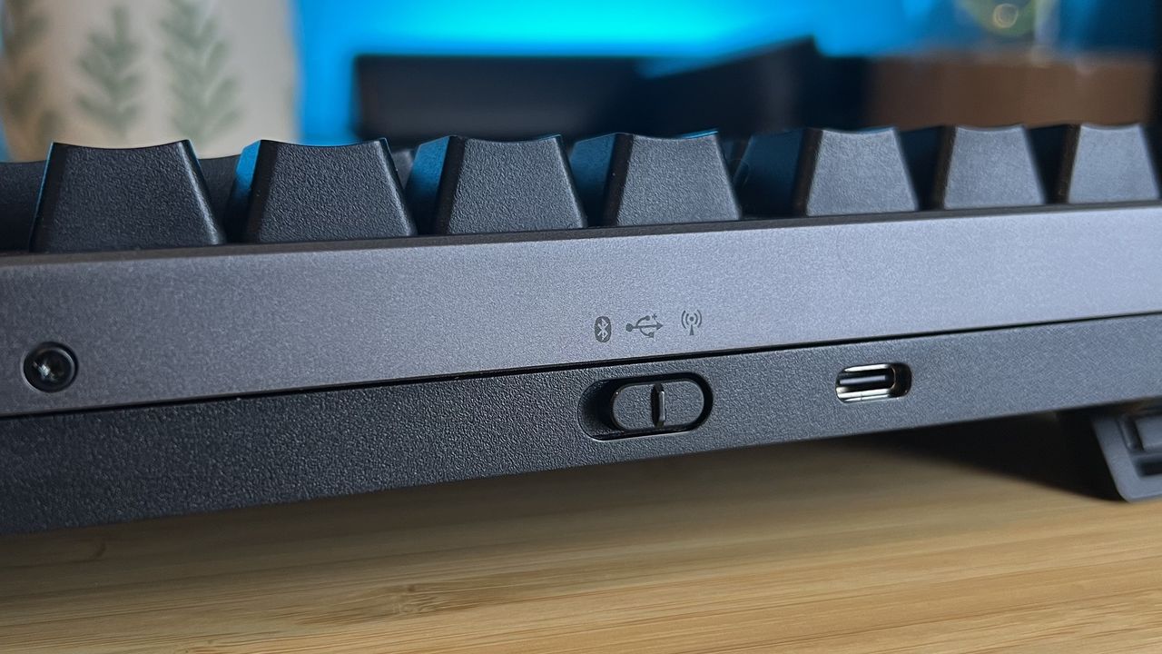 Close up on wireless connection toggle on the front edge of Asus ROG Strix Morph 96 Wireless gaming keyboard