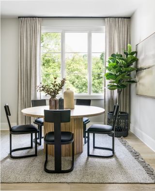 neutral dining room with round table and rug by Lindye Galloway