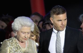 Queen Elizabeth II and musician Gary Barlow on stage during the Diamond Jubilee concert at Buckingham Palace on June 4, 2012