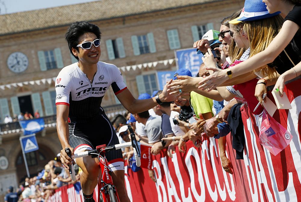 Japanese cyclist Fumiyuki Beppu greets people as he arrives for the start of the 10th stage