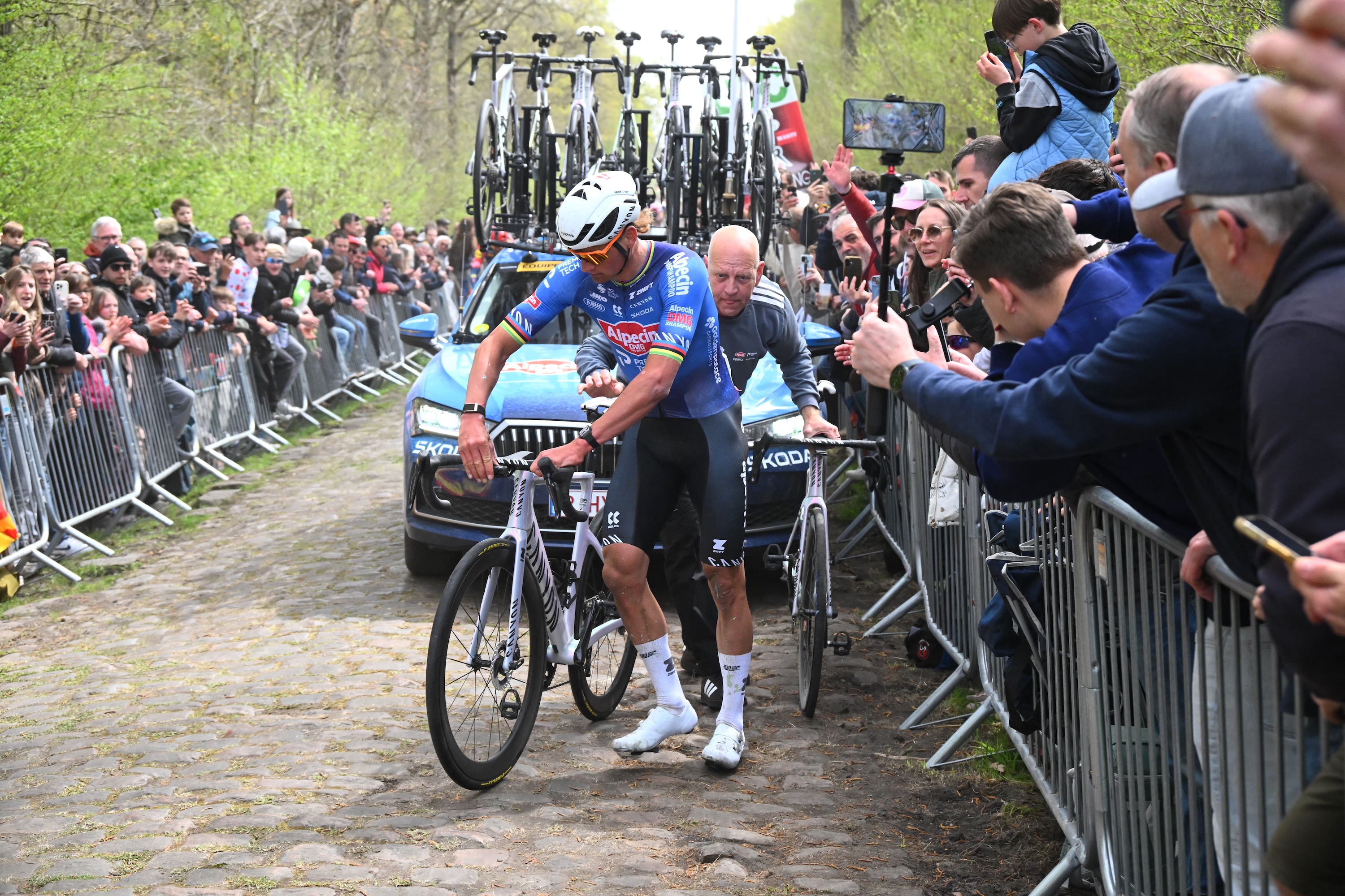 Alpecin-Premier Tech's Dutch rider Mathieu van der Poel changes his bike after a flat tire at the 'Trou&eacute;e d&rsquo;Arenberg' cobblestone sector 