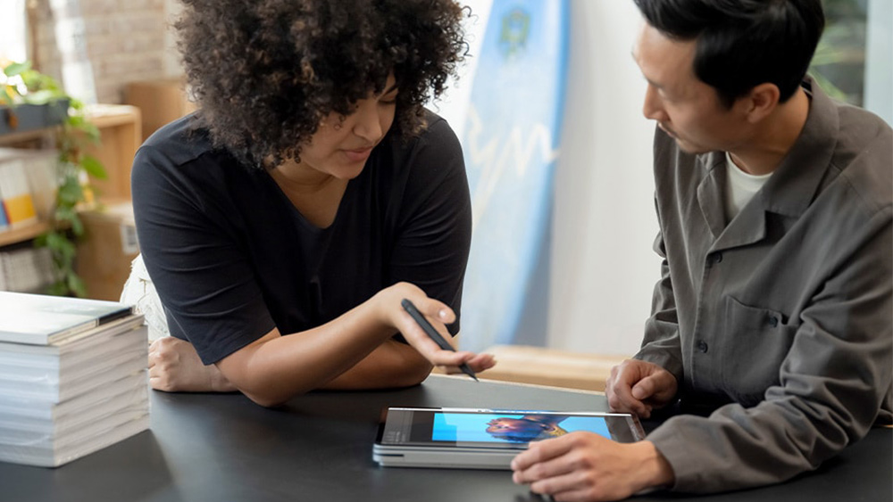 Two creatives look at the screen on the Surface Laptop Studio, one of the best 2-in-1 laptops