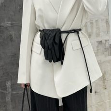 Danish fashion influencer Singe Emilie Olesen wearing black leather gloves tucked into a leather cord belt around a white blazer