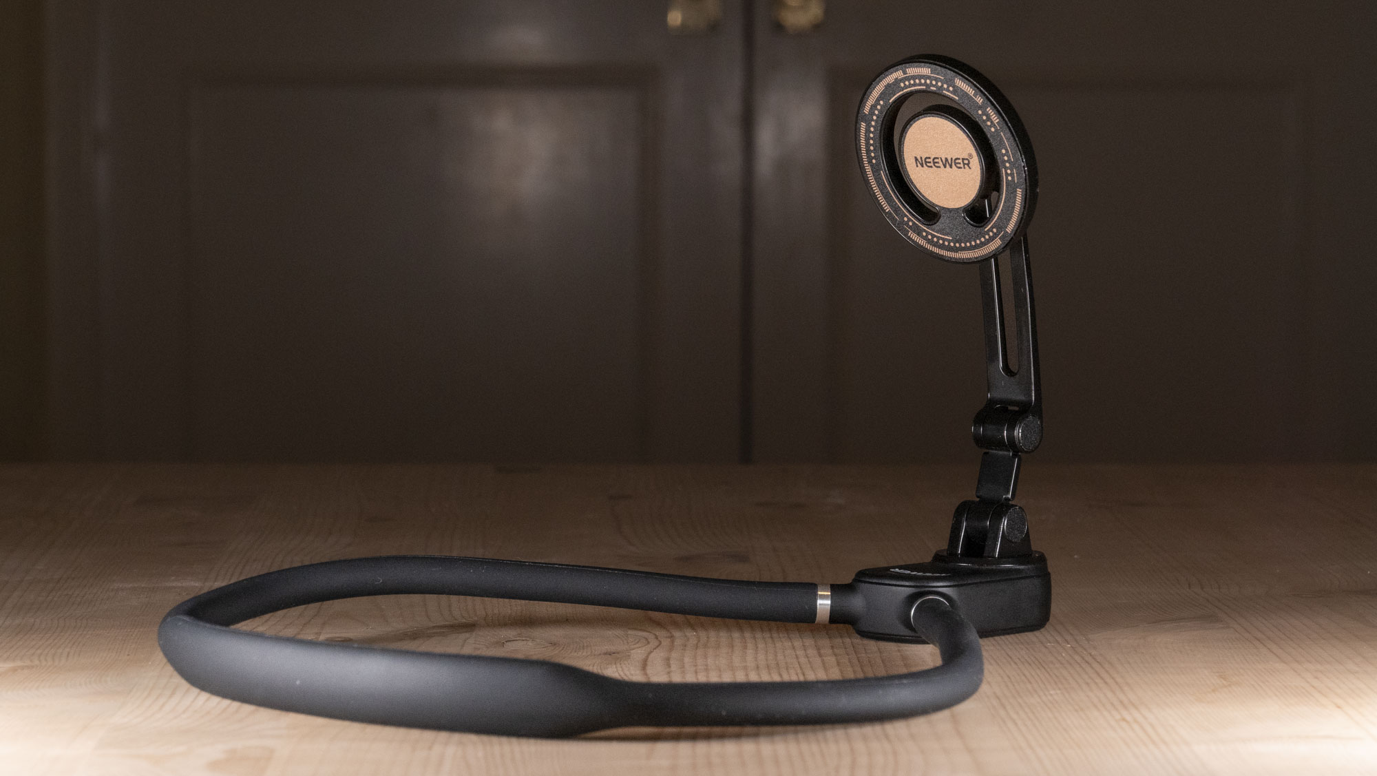 Магнитный шейный бандаж Neewer на деревянном столе.